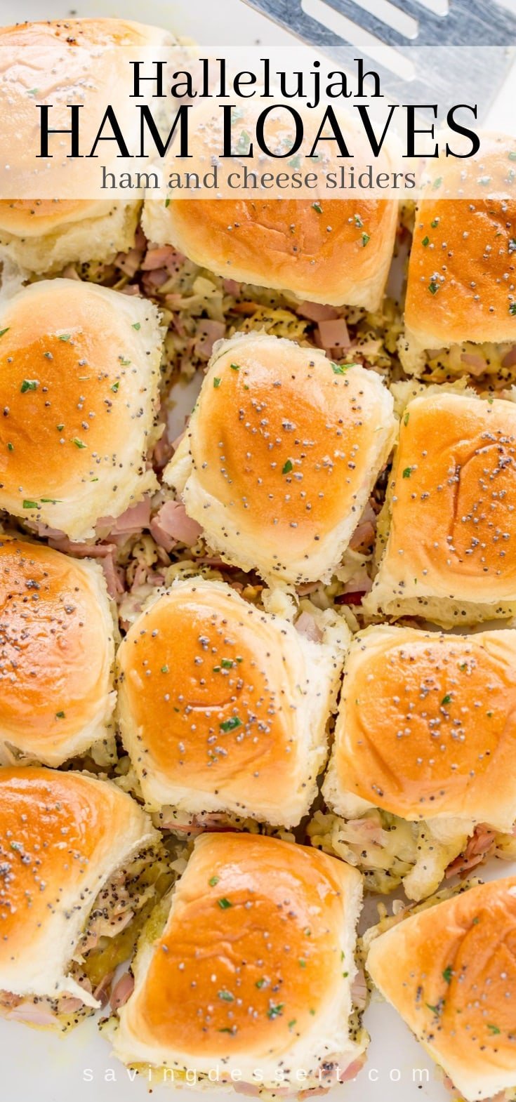 A platter of ham and cheese slider sandwiches topped with poppy seeds
