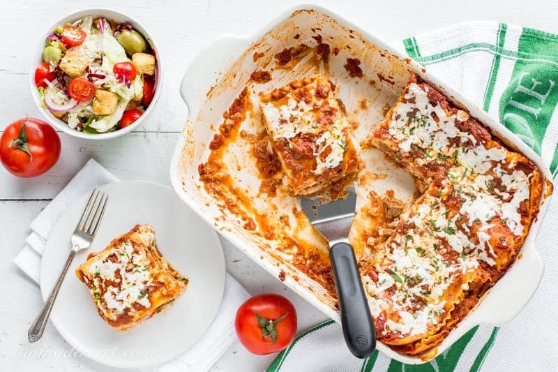 Meaty, cheesy homemade lasagna with fresh tomatoes and salad on the side from www.savingdessert.com