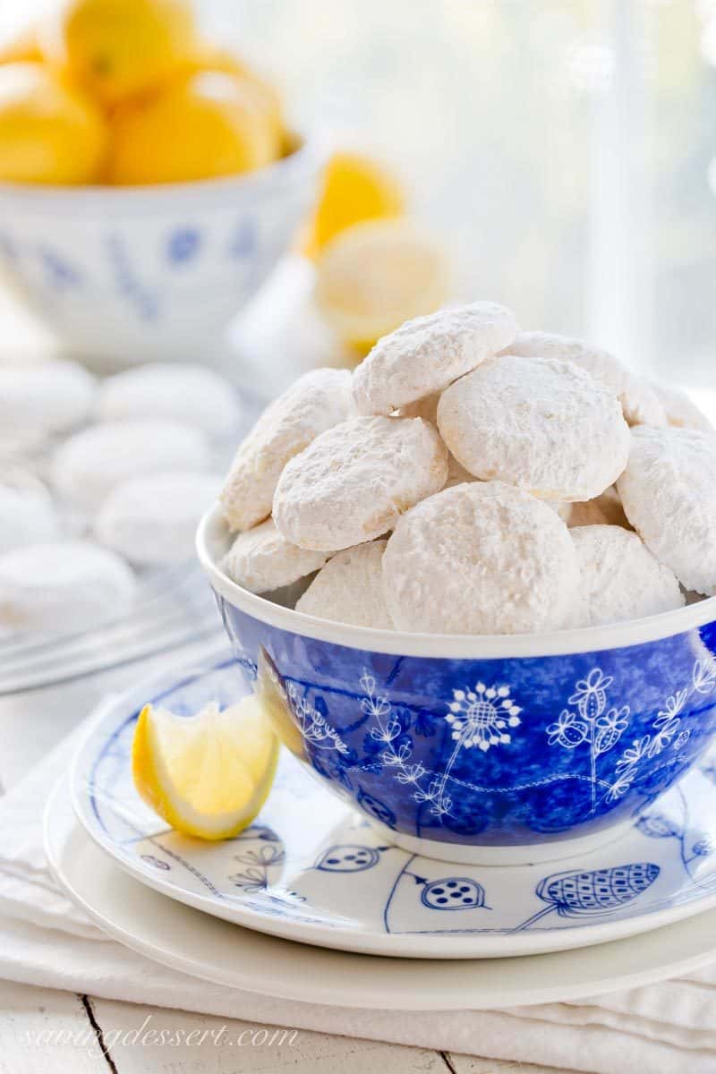 Lemon Cooler cookies in a blue bowl with sliced lemons