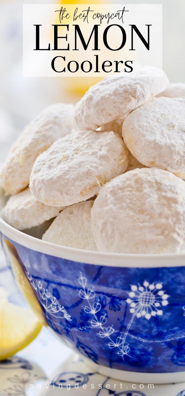 A blue bowl filled with powder sugar covered lemon cookies