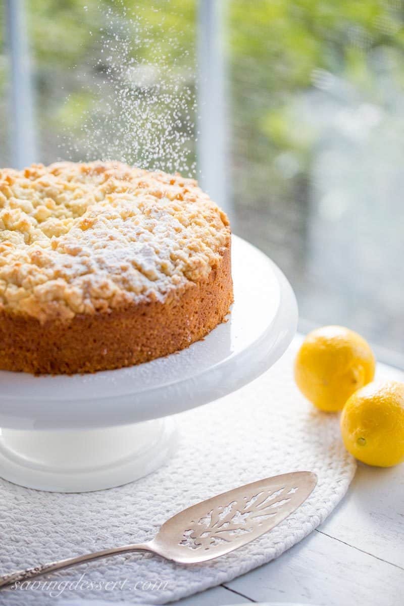 Lemon Crumble Breakfast Cake on a platter dusted with powdered sugar