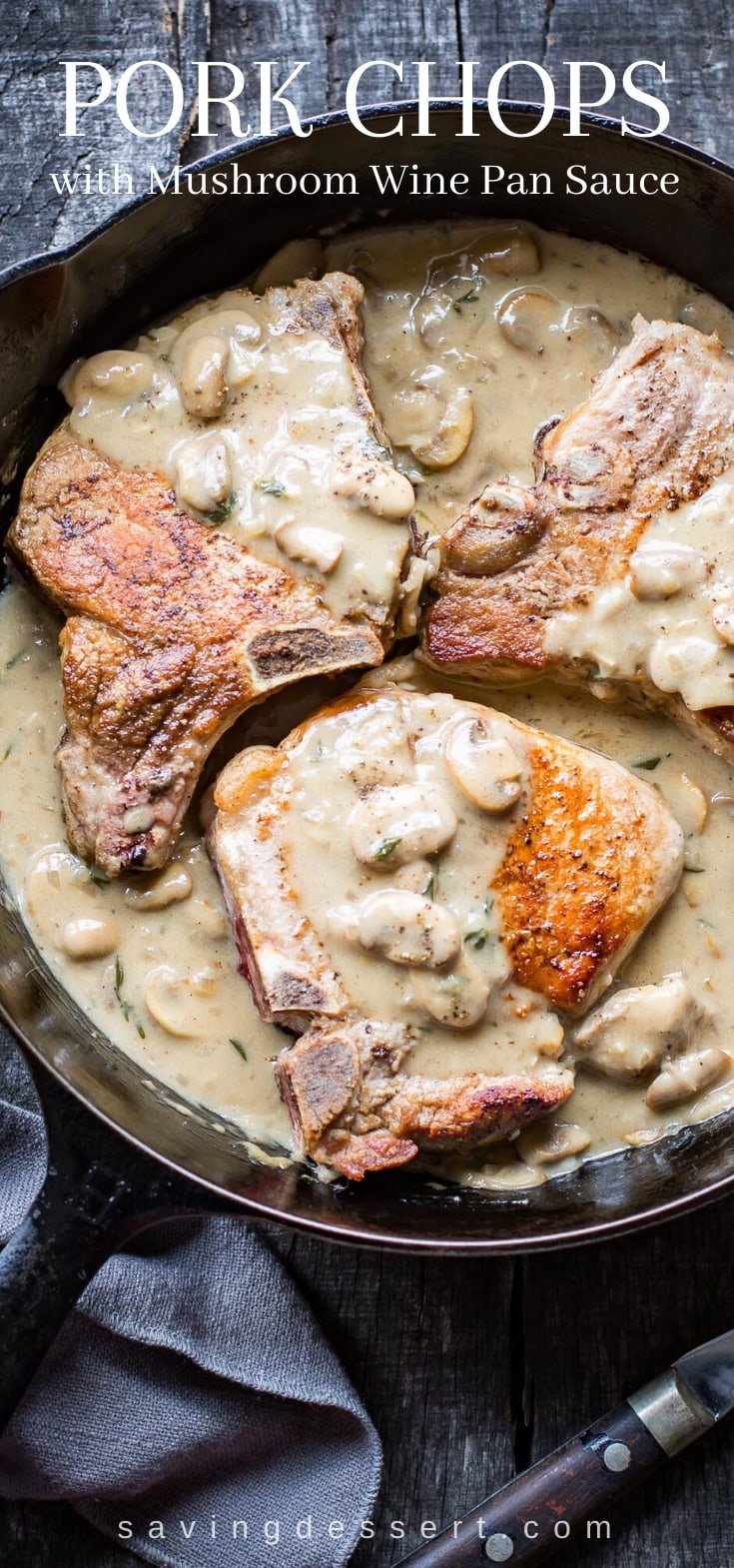 A cast iron skillet with bone-in pork chops and mushroom wine gravy