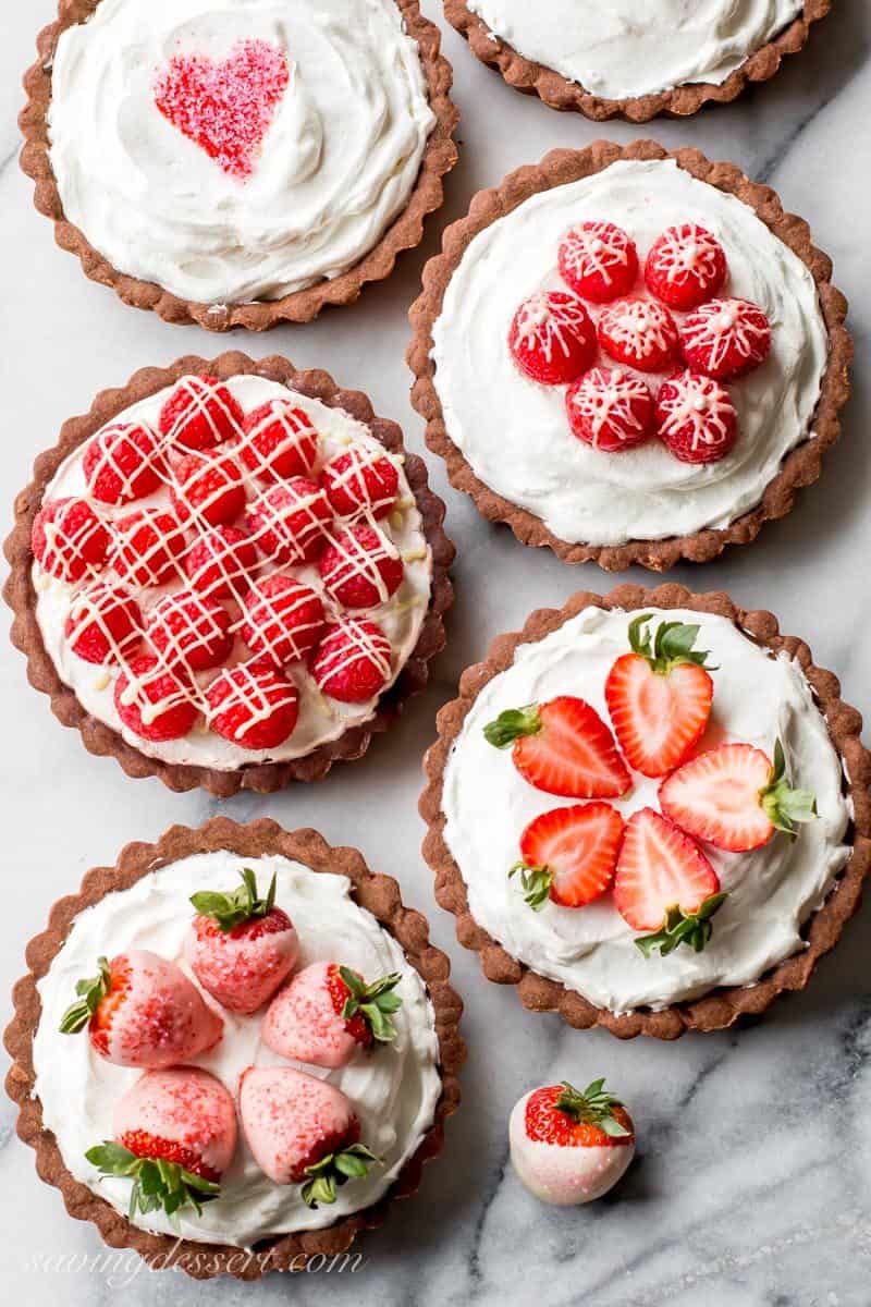 Chocolate Tarts with White Chocolate Mousse filling topped with sprinkle hearts, strawberries and raspberries