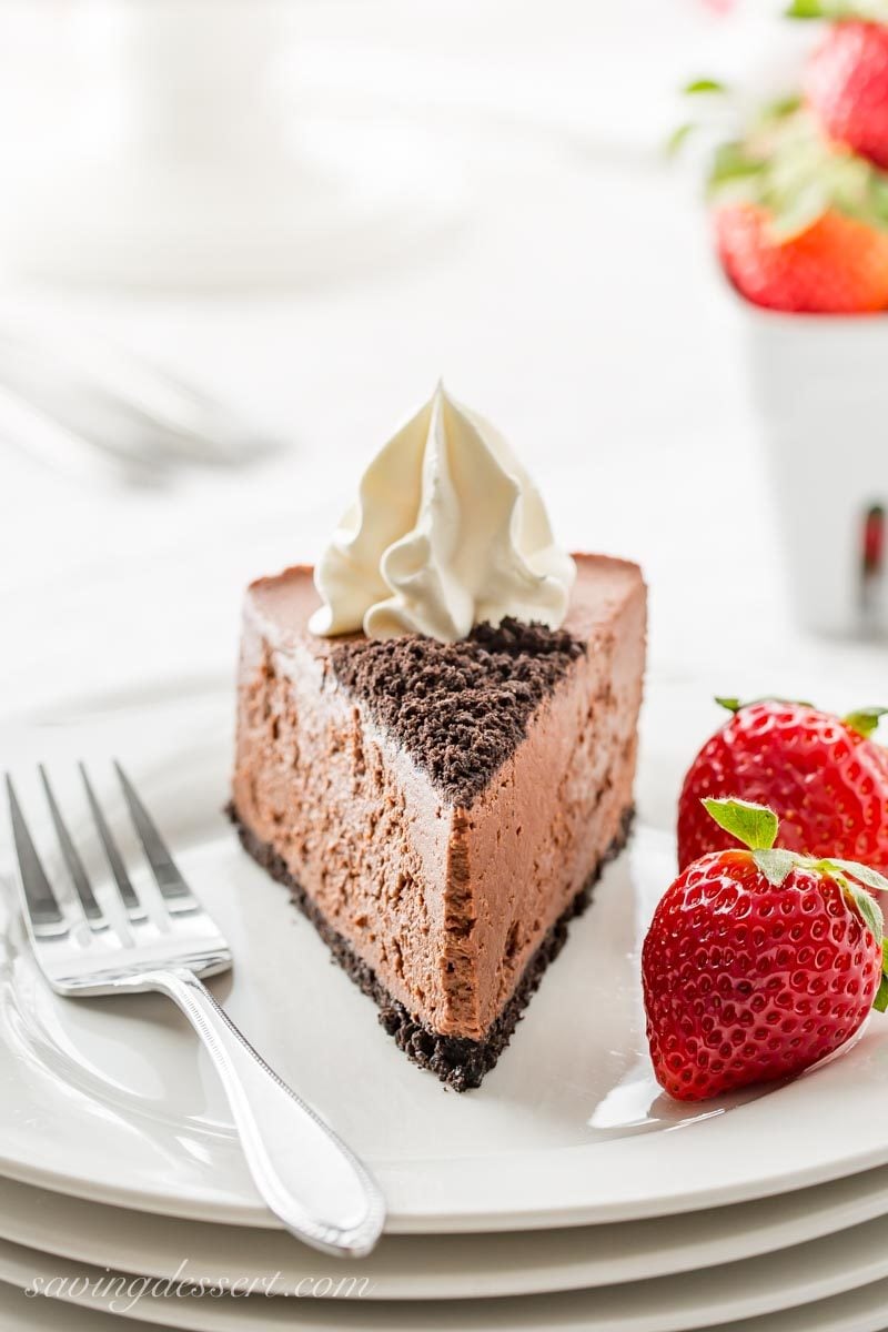 a slice of baileys chocolate cheesecake with whipped cream and strawberries