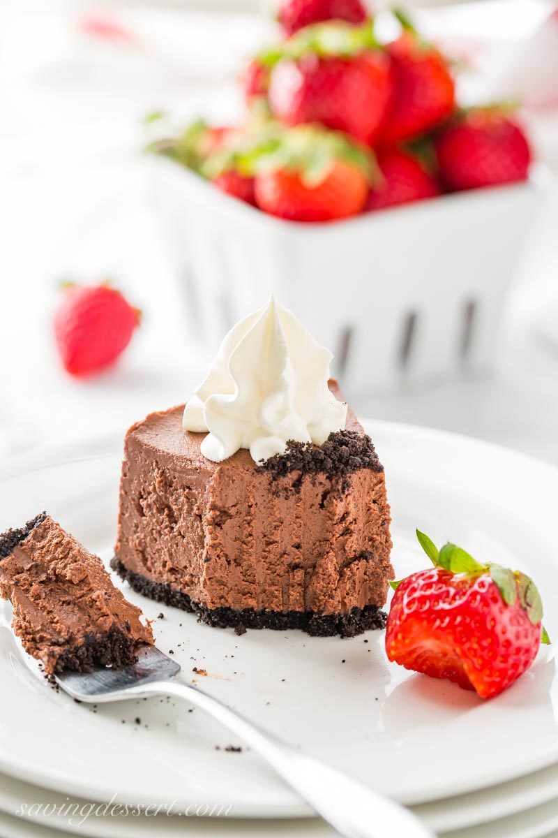 a slice of baileys chocolate cheesecake with whipped cream and strawberries