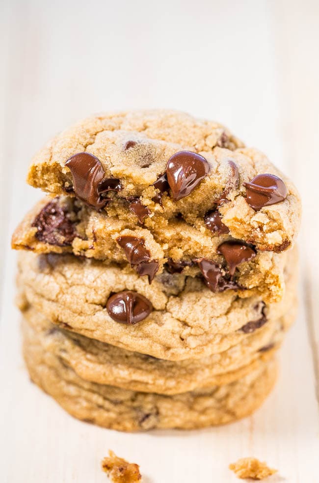 a stack of chocolate chip cookies with melted morsels on top