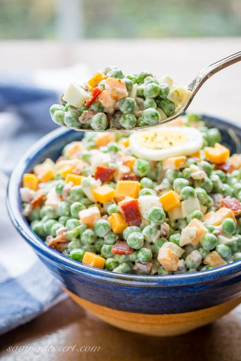 A bowl of English Pea Salad with chopped hard cooked eggs, bacon and cheese