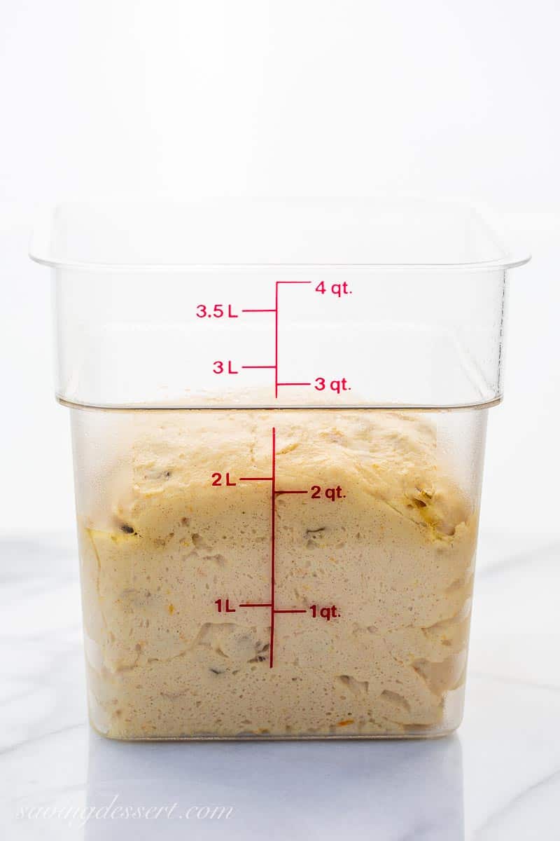 A clear plastic container filled with risen dough