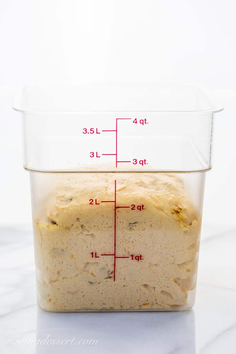 A clear plastic container filled with risen dough