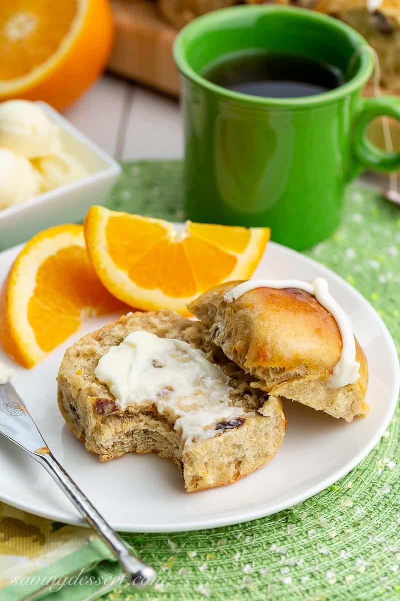A sweet bun on a plate with oranges and butter
