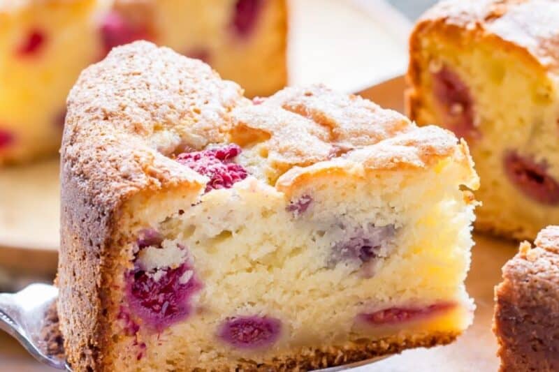 A slice of raspberry ricotta breakfast cake on a cake server.