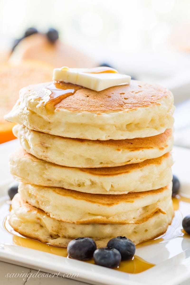 ricotta pancakes with syrup, blueberries and a pat of butter