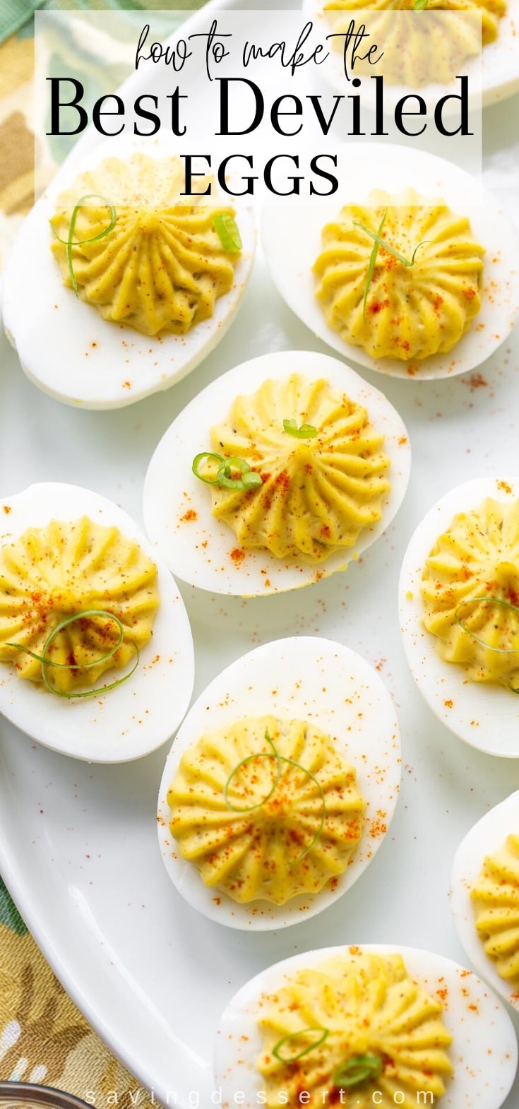 a platter of deviled eggs garnished with paprika and thin sliced green onions