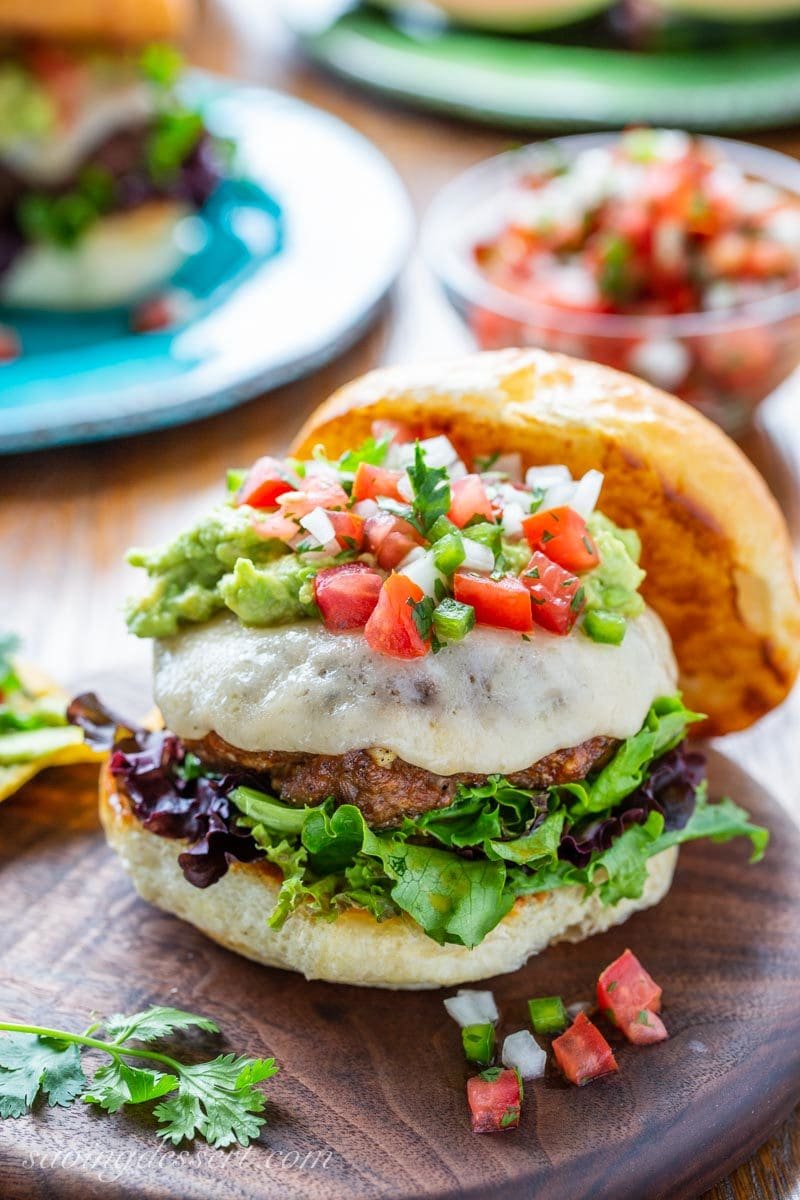 Taco Burger with melted cheese, pico de gallo and smashed avocado.