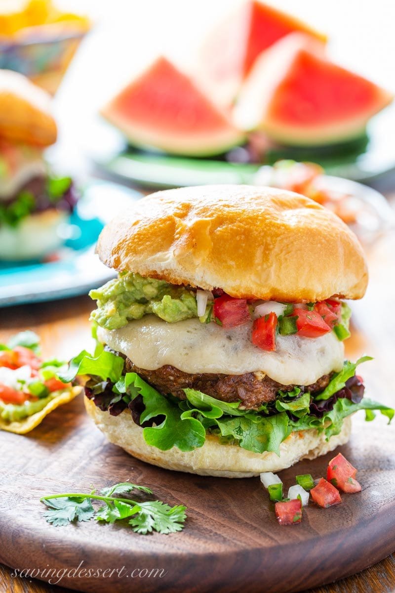 Taco burger with melted cheese, pico de gallo, smashed avocado, lettuce and watermelon