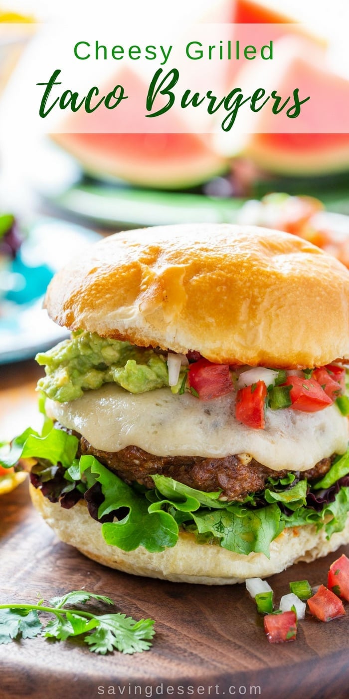 Cheesy Grilled Taco Burgers - all the Mexican flavors you love, in one tasty burger! This is not your same old dried-up burger; it's cheesy and juicy with plenty of flavor without being salty or too intense. #savingroomfordessert #burger #taco #tacotuesday #grilledburger #hamburger #mexicanburger #cheeseburger #tacoburger #mexican