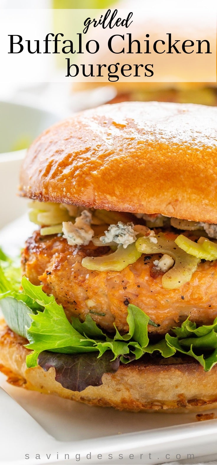 A close up of a grilled Buffalo Chicken burger with blue cheese, lettuce and a celery salad on a toasted bun