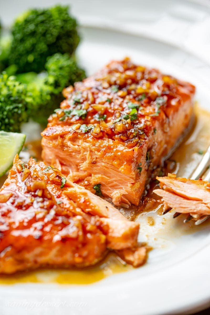 Spicy glazed salmon in a sauce served with broccoli on a plate