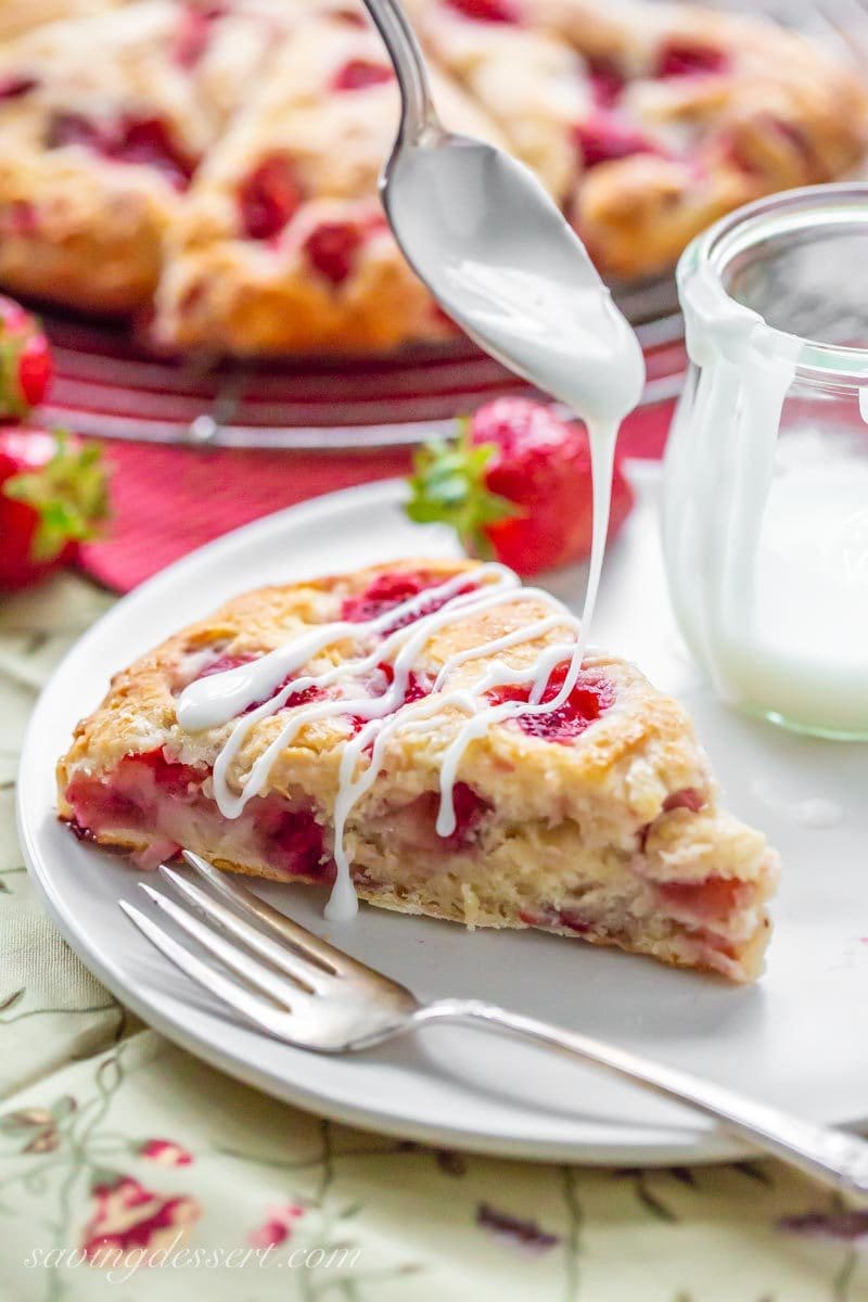 Strawberry Biscuit Wedges on a plate being drizzled with icing