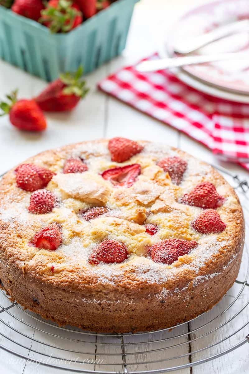 A single layer strawberry cake on a wire rack