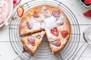 Sliced strawberry breakfast cake dusted with powdered sugar