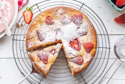 Sliced strawberry breakfast cake dusted with powdered sugar