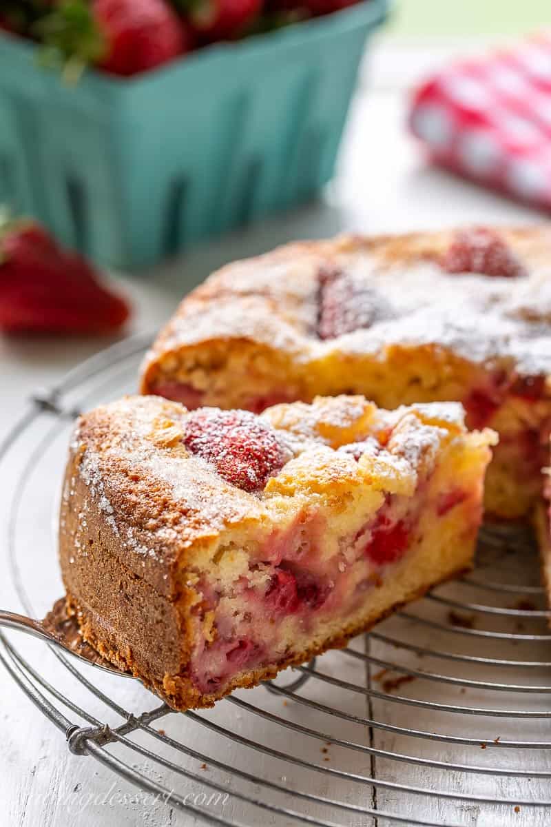 A slice of strawberry cake on a wire rack