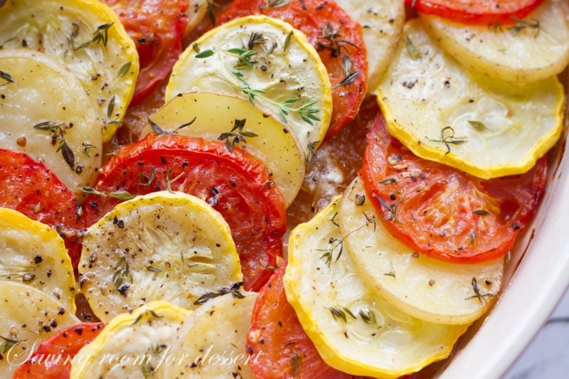 A casserole with tomatoes, potatoes, squash and onions layered 