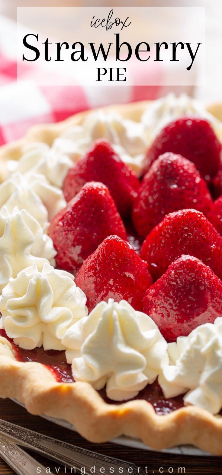 A strawberry pie with whole berries on top garnished with whipped cream