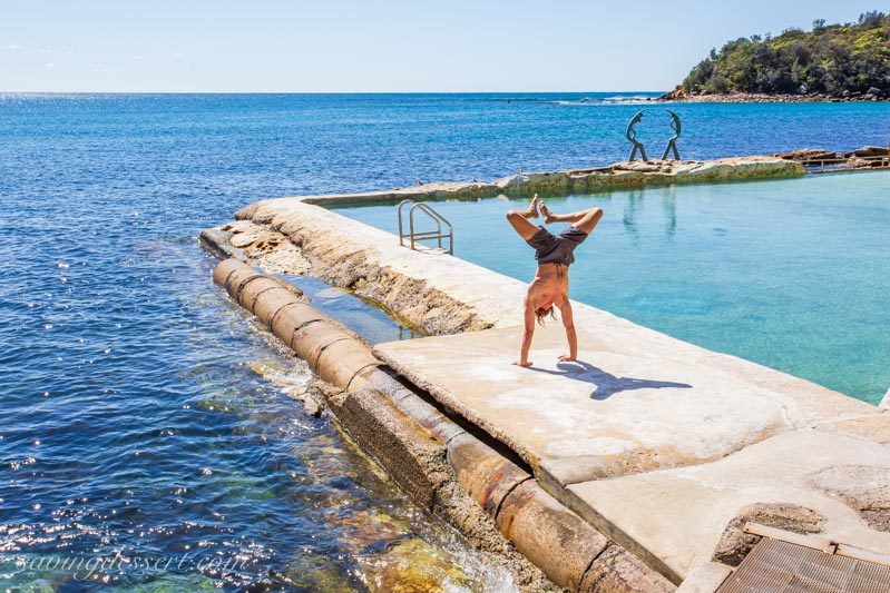 A man doing yoga next to Fairy Bower saltwater rock pool on Manly, Sydney Australia