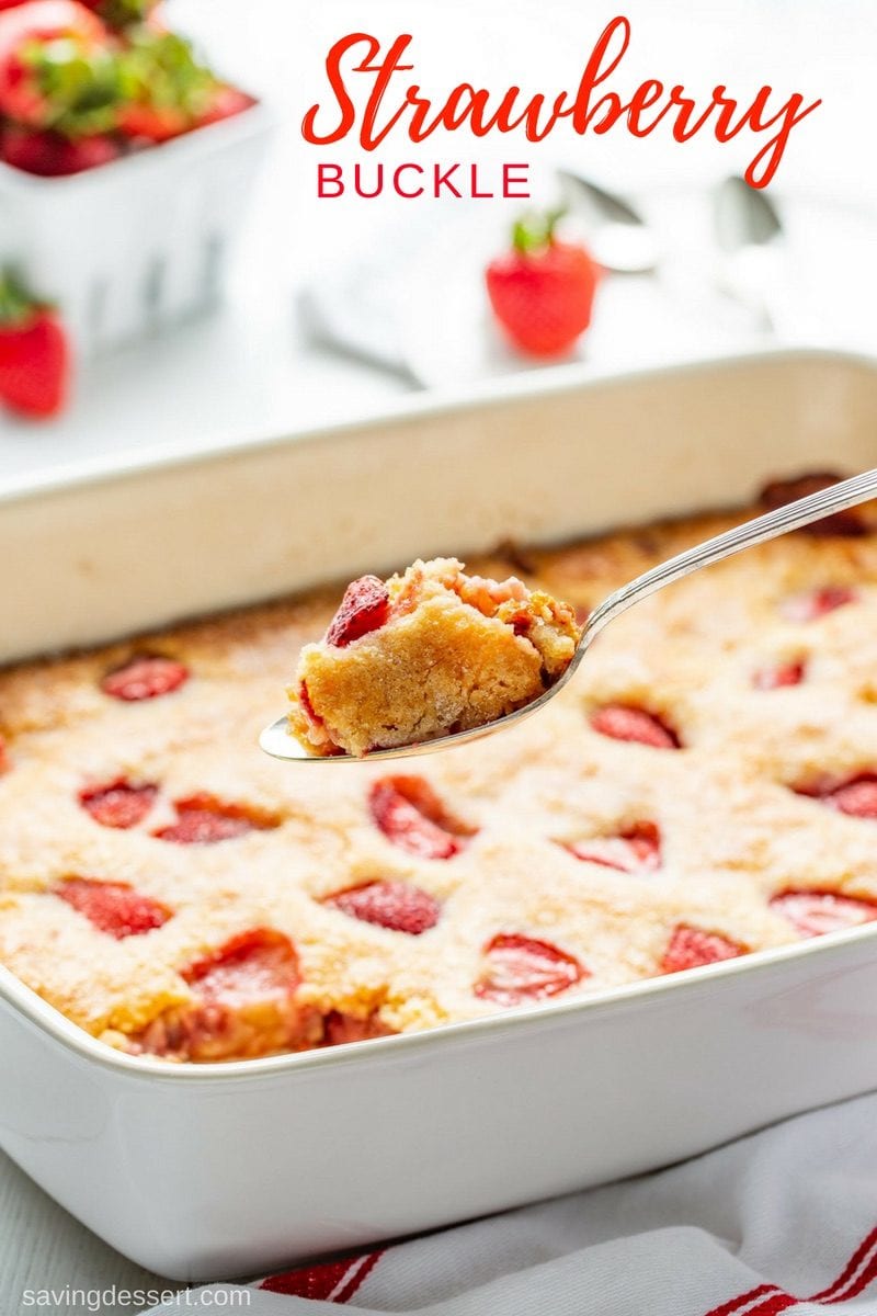 A spoonful of strawberry buckle over a casserole pan