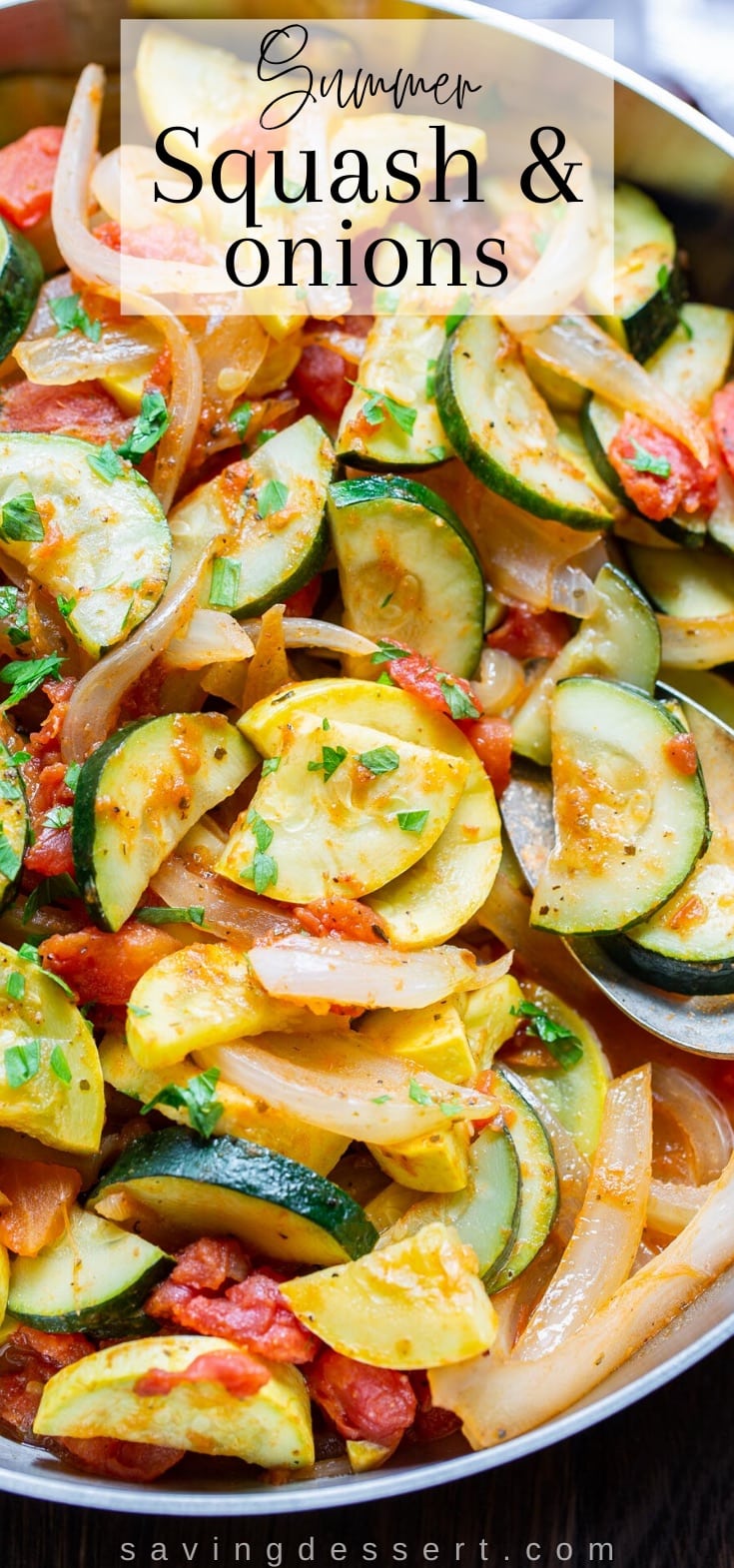 an overhead shot of a skillet filled with yellow squash, zucchini, onions and tomatoes