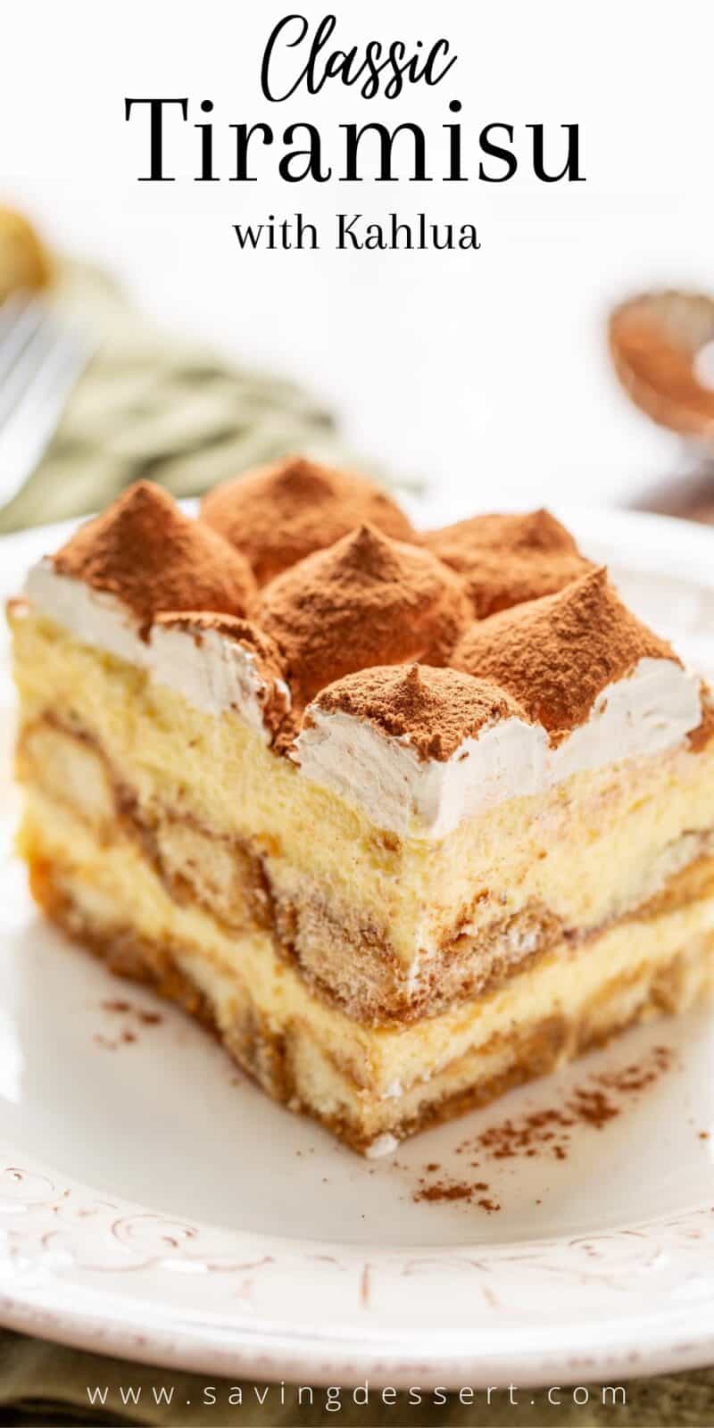 A side view of a slice of tiramisu dusted with cocoa powder on top