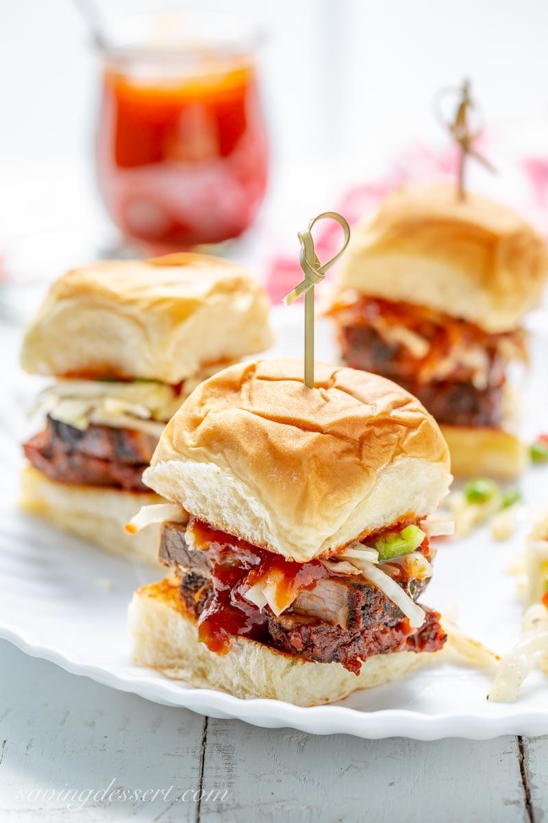 Toasted rolls with sliced beef brisket, Cole slaw and BBQ sauce on a plate