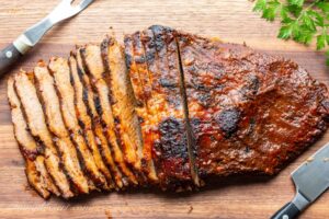 Thin sliced BBQ'd beef brisket on a cutting board