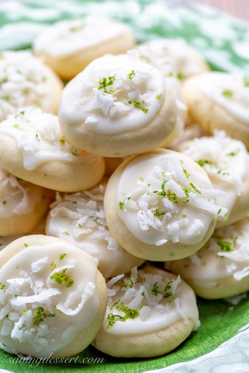 A plate full of Coconut Key Lime Meltaway Cookies with flaked coconut and lime zest on top