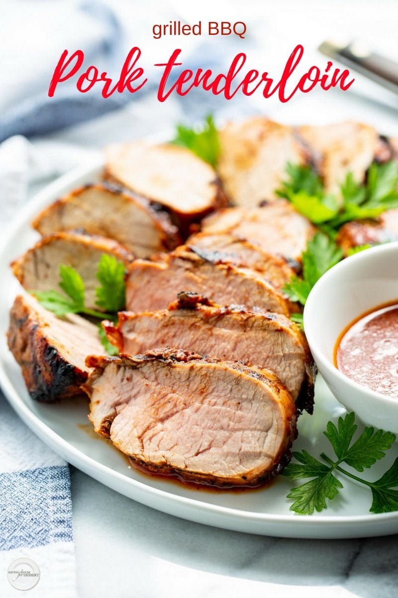 A platter with sliced grilled pork tenderloin served with a bowl of sauce