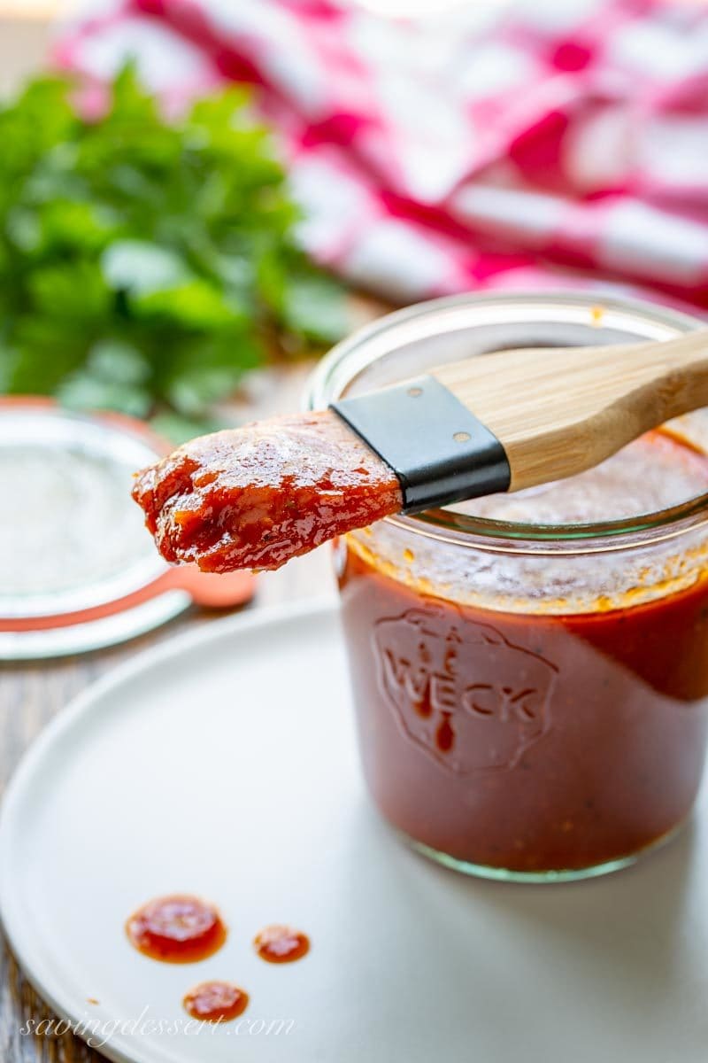 Homemade BBQ sauce on a plate with a basting brush dripping