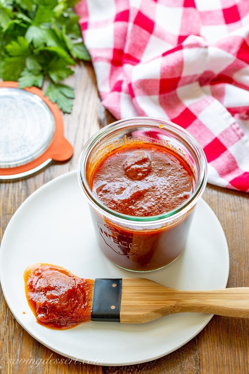 Homemade Honey BBQ sauce in a wide mouth jar on a plate