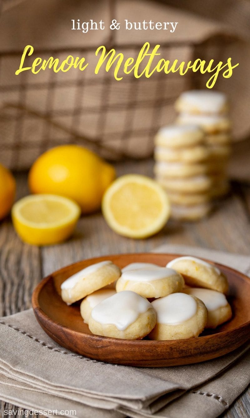 Lemon Meltaways on a plate with fresh lemons and a basket