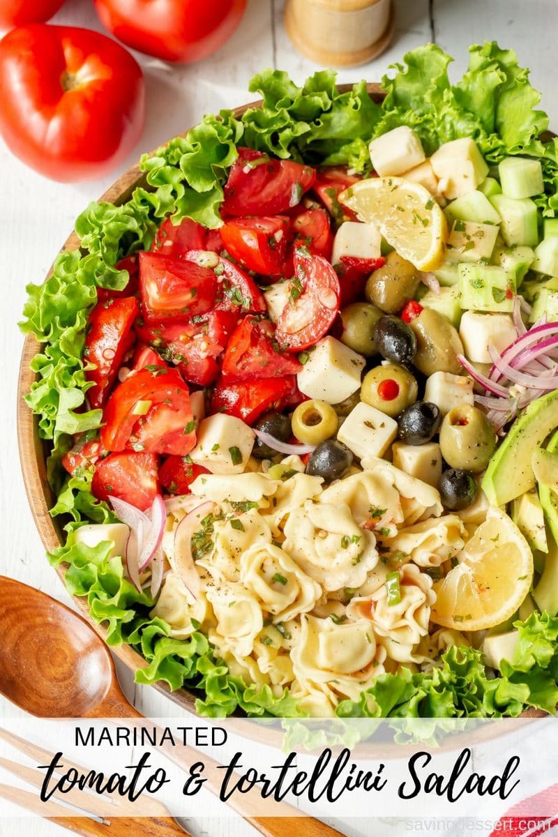 Marinated Tomato & Tortellini Salad with cucumbers, onion, olives, avocado, cheese and fresh garden herbs. Don't forget the crusty bread to soak up all the juices! #savingroomfordessert #salad #tortellini #tomatoes #heartysalad #tomatorecipes #tomatosalad
