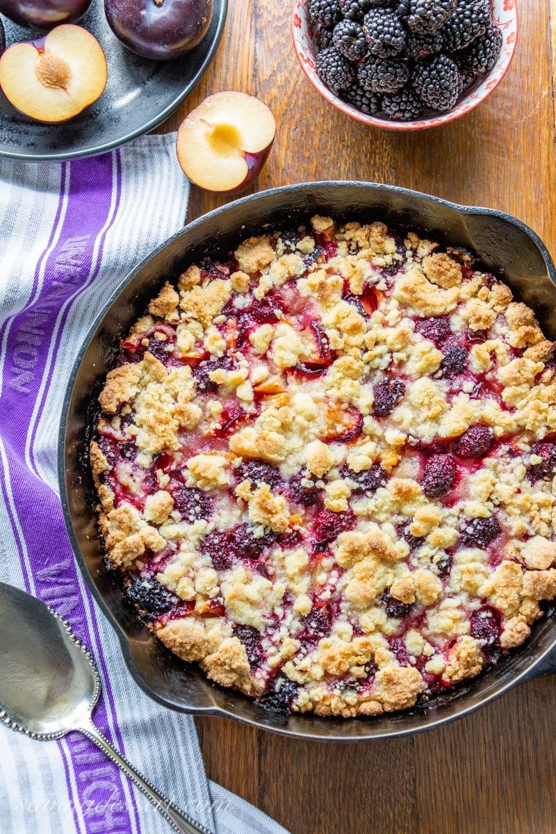 Cast iron skillet with plum blackberry bars and a shortbread crumble dough on top