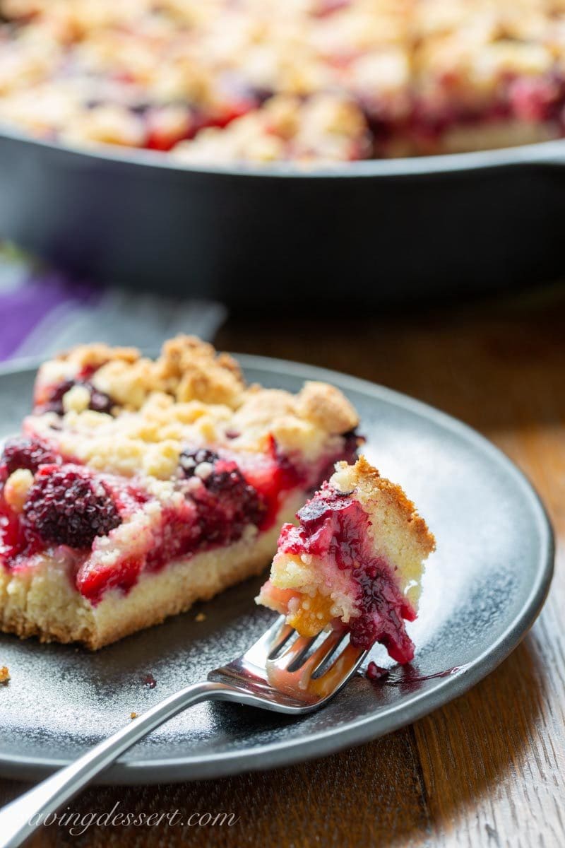 A slice of blackberry plum bars with a fork