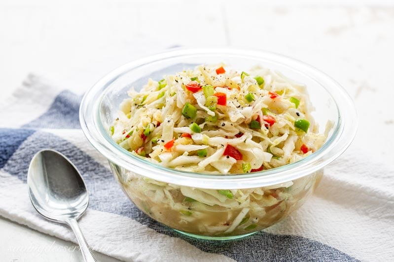 A bowl of vinegar based Cole slaw with cabbage, pimentos and green peppers