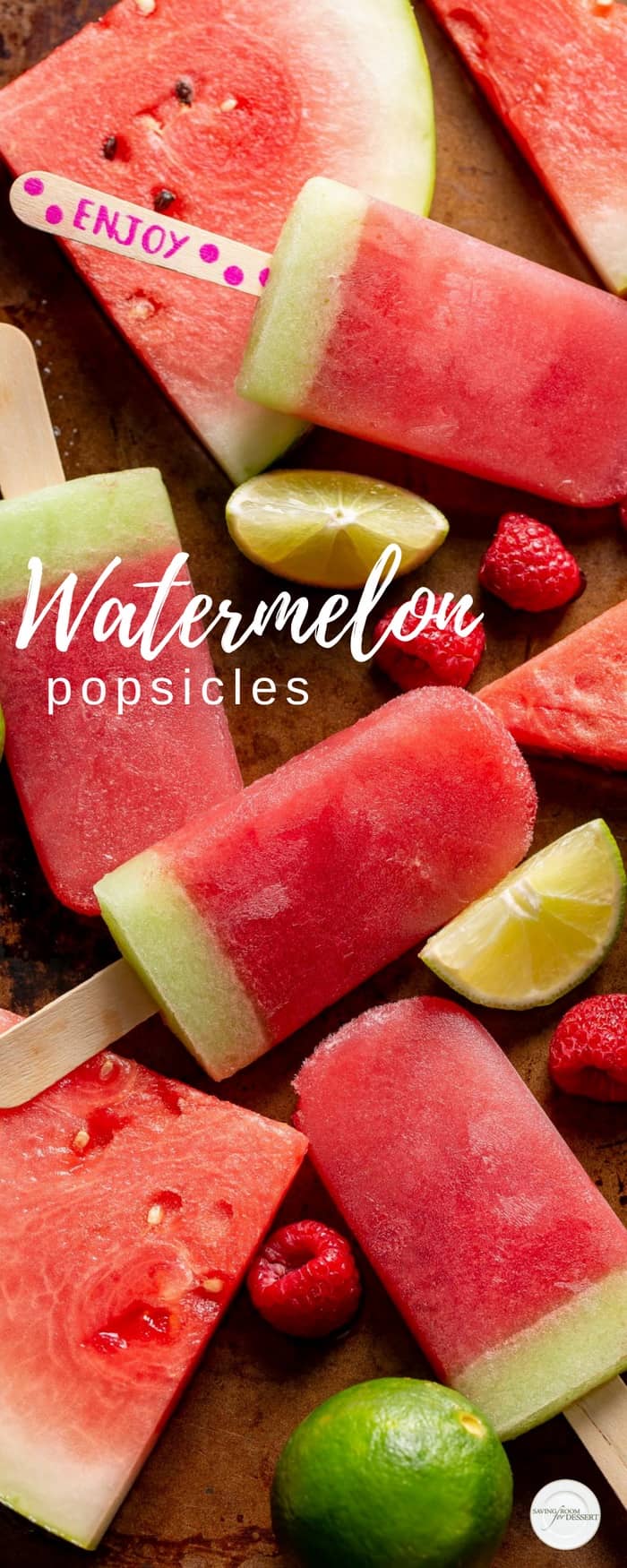 Watermelon popsicles scattered on a baking tray with raspberries, lime wedges and pieces of watermelon