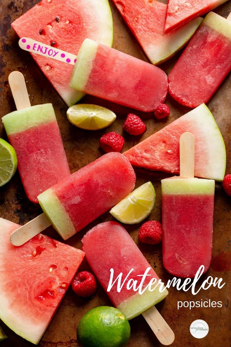 A baking tray stacked with watermelon popsicles