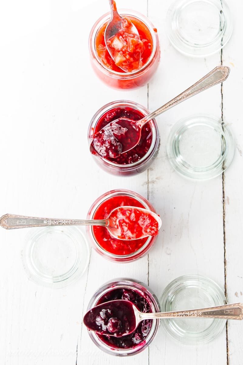 jars of berry sauce with spoons