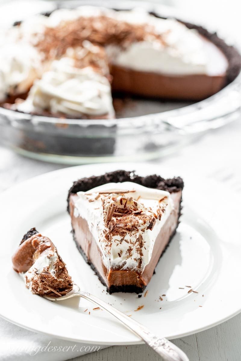 a slice of double chocolate cream pie with a chocolate crust, whipped cream and chocolate shavings on top