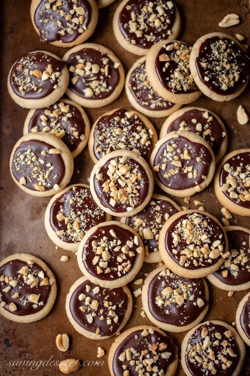 A cookie sheet full of peanut butter chocolate meltaway cookies with chopped peanuts on top
