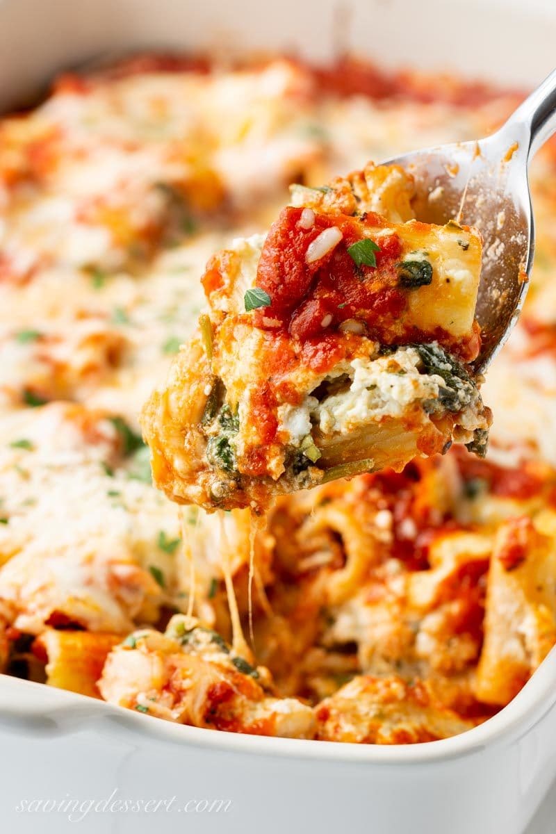 a spoonful of rigatoni pasta, marinara sauce, spinach and a ricotta cheese mixture